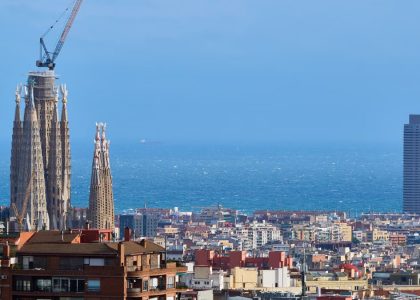 A vibrant view of Barcelona's skyline with La Sagrada Familia and the Mediterranean Sea in the background.